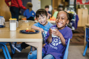 Young children eating a healthy meal at the Goodman Community Center